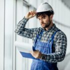 happy-young-man-architect-hard-hat-holding-folder-scaled-1